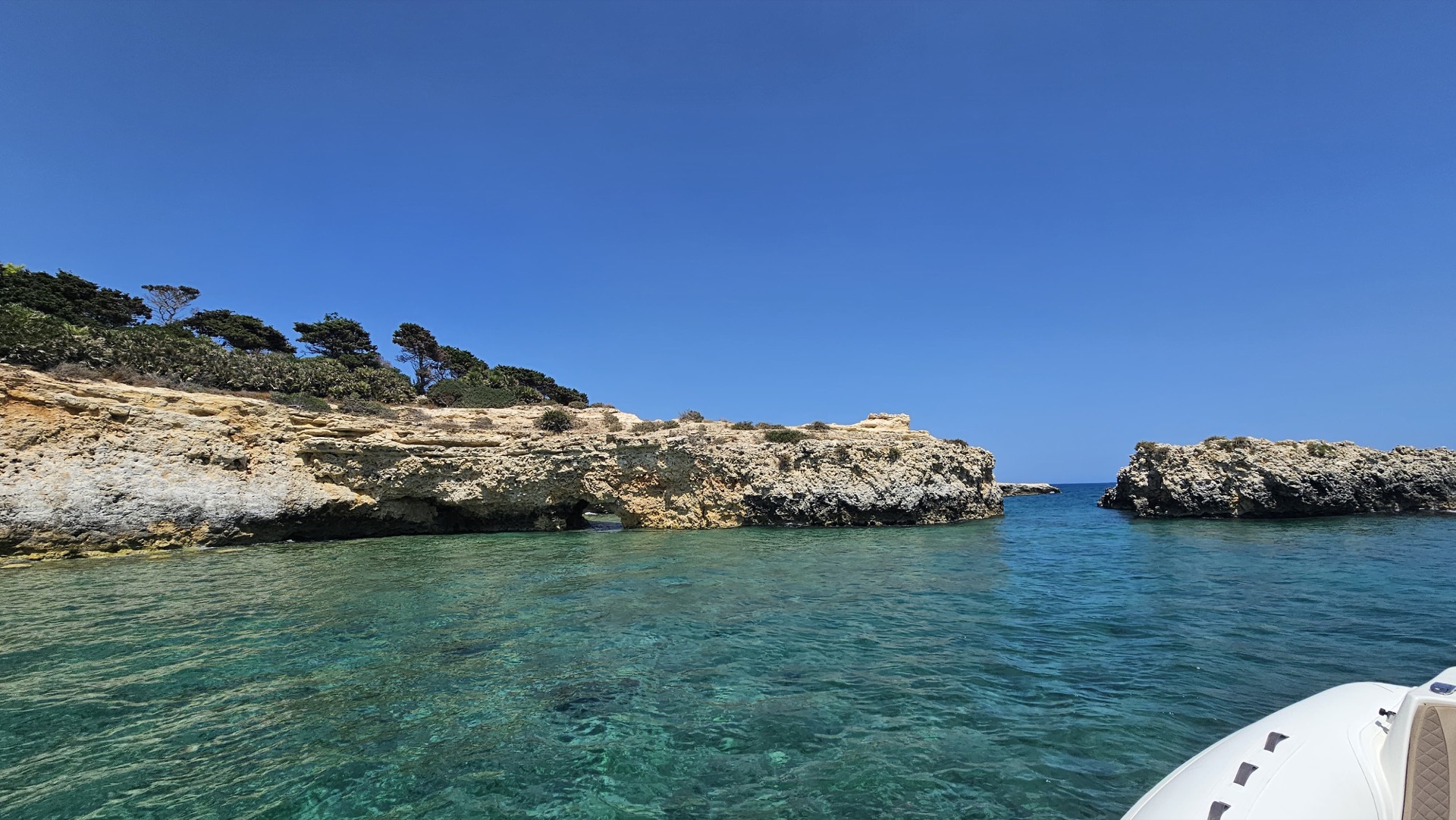 Caletta rocciosa dalle acque turchesi lungo la costa di Siracusa