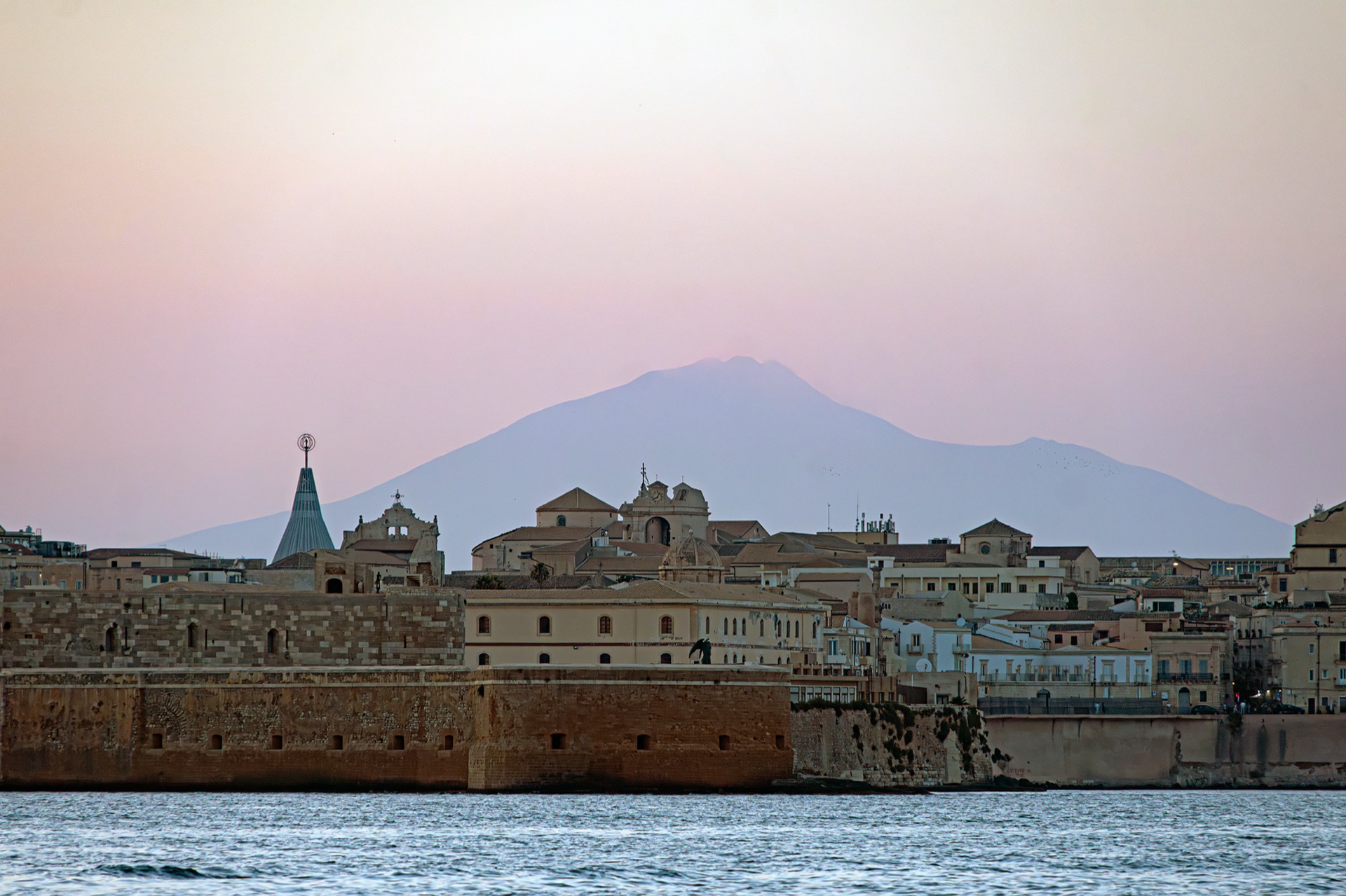 Skyline di Ortigia con l'Etna sullo sfondo al tramonto